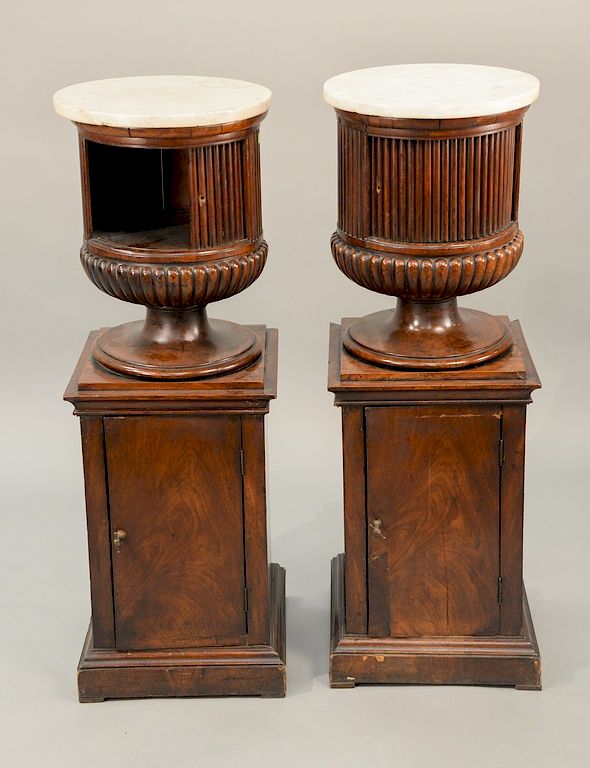 Appraisal: Pair of mahogany classical style cabinets with marble top urn