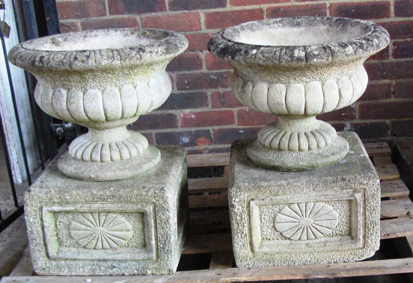 Appraisal: A pair of reconstituted stone garden urns with semi fluted