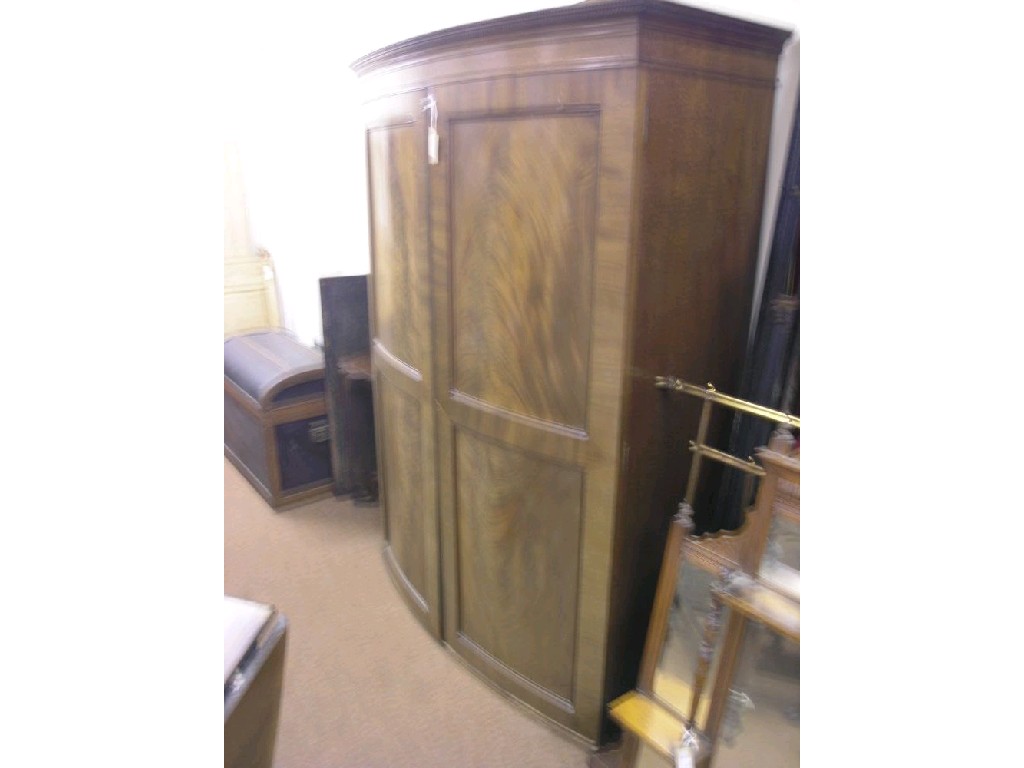 Appraisal: A late Victorian mahogany bow-fronted wardrobe enclosed by a pair