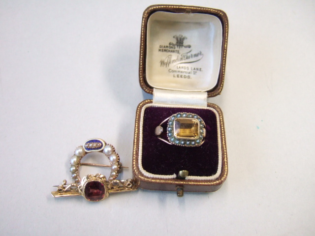 Appraisal: A garnet set single stone gold bar brooch a gold