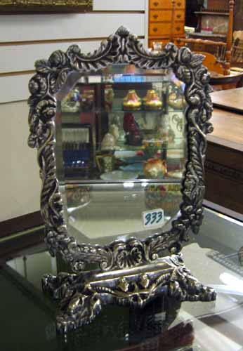 Appraisal: AN ENGRAVED SILVERED METAL DRESSING TABLE MIRROR in a floral