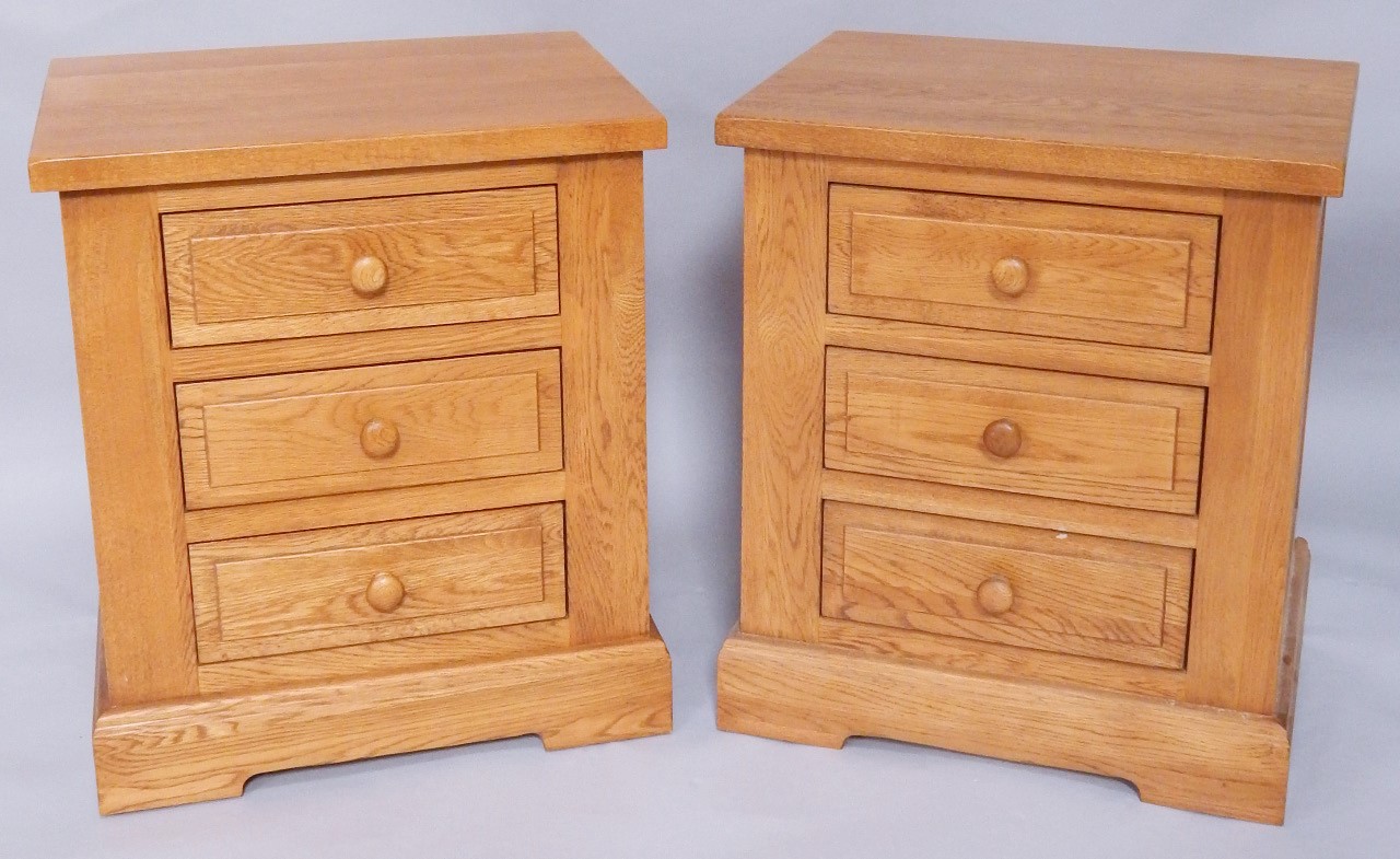 Appraisal: A pair of light oak three drawer bedside chests width