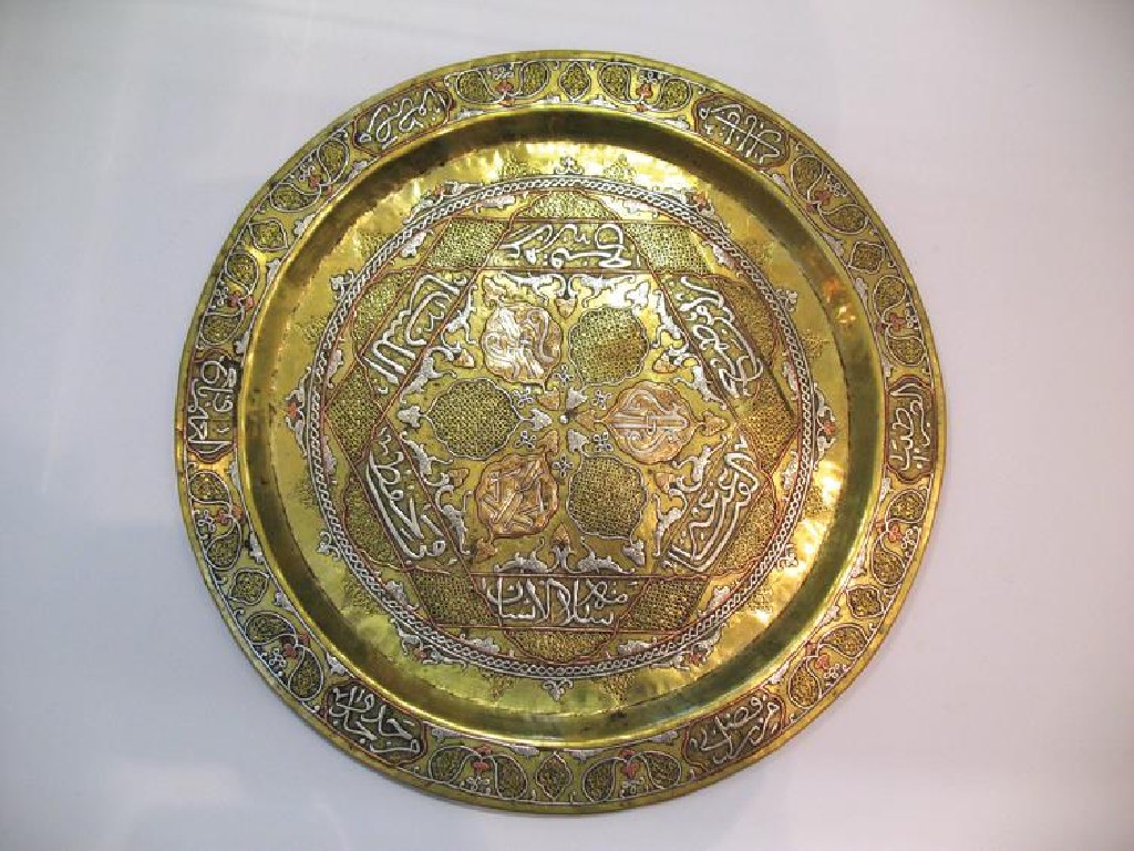 Appraisal: AN INDO-PERSIAN BRASS DISH with silver inlay of script complex