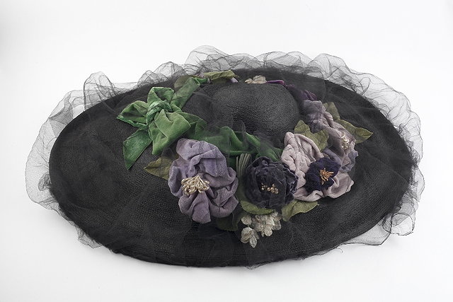 Appraisal: An Edwardian black straw hat with velvet trim and mesh