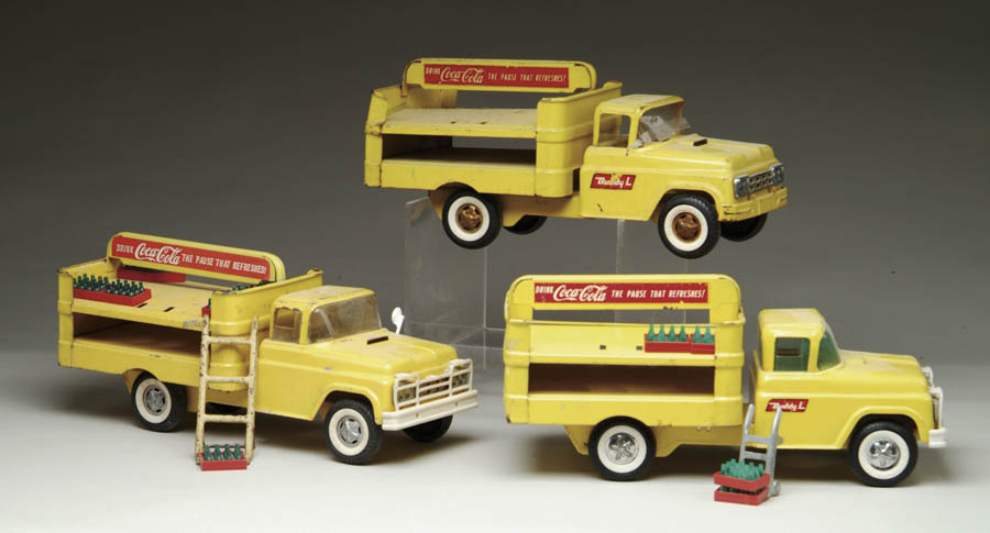 Appraisal: THREE BUDDY L COCA-COLA TRUCKS Three yellow Coca-Cola trucks from