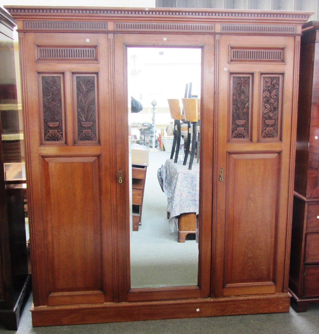 Appraisal: A late th century walnut compactum wardrobe with mirrored central