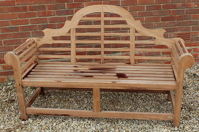 Appraisal: A LUTYENS STYLE TEAK GARDEN BENCH with scroll arms cm