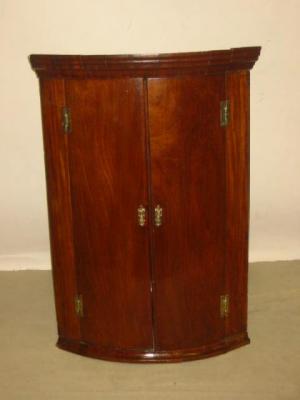 Appraisal: A GEORGE III MAHOGANY CORNER CUPBOARD of quadrant form with