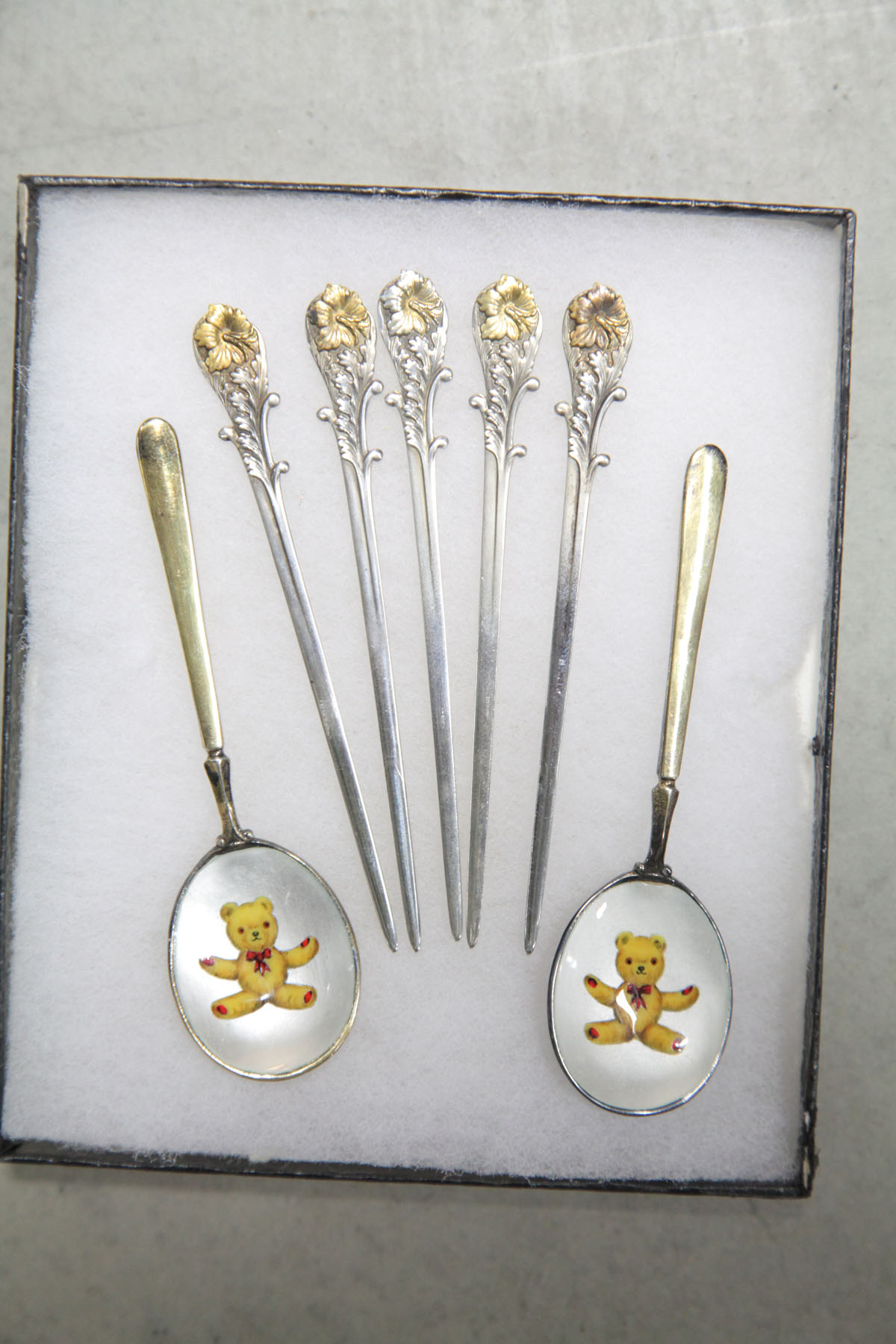 Appraisal: SEVEN PIECES Five silver picks with gold wash flower decoration