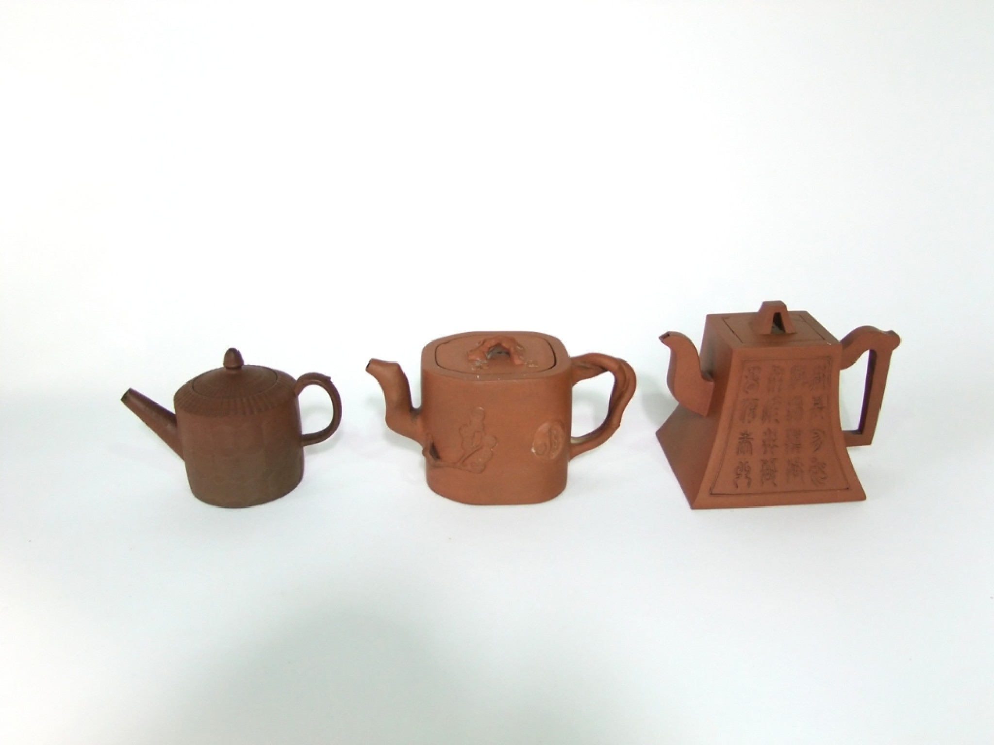 Appraisal: Two oriental terracotta teapots comprising a four sided example with