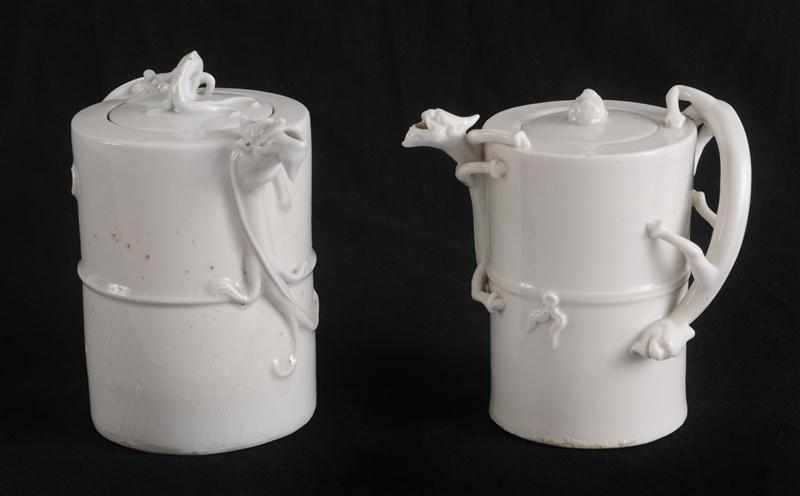 Appraisal: TWO CHINESE IVORY-GLAZED PORCELAIN CYLINDRICAL TEAPOTS AND COVERS Each with