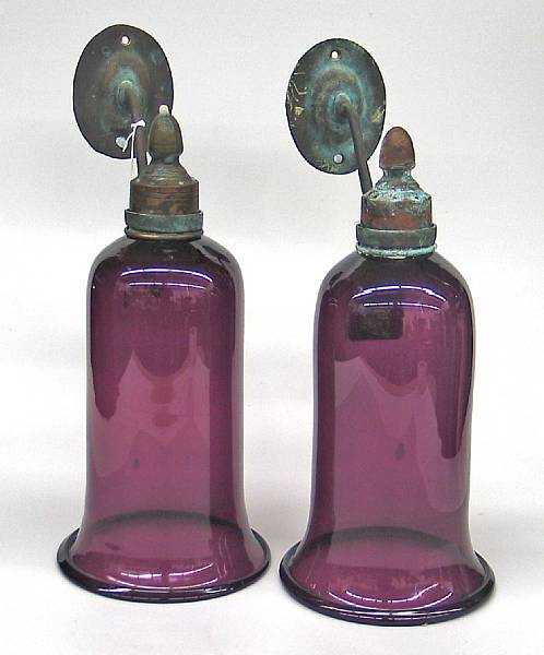 Appraisal: A pair of amethyst glass and patinated brass wall lights