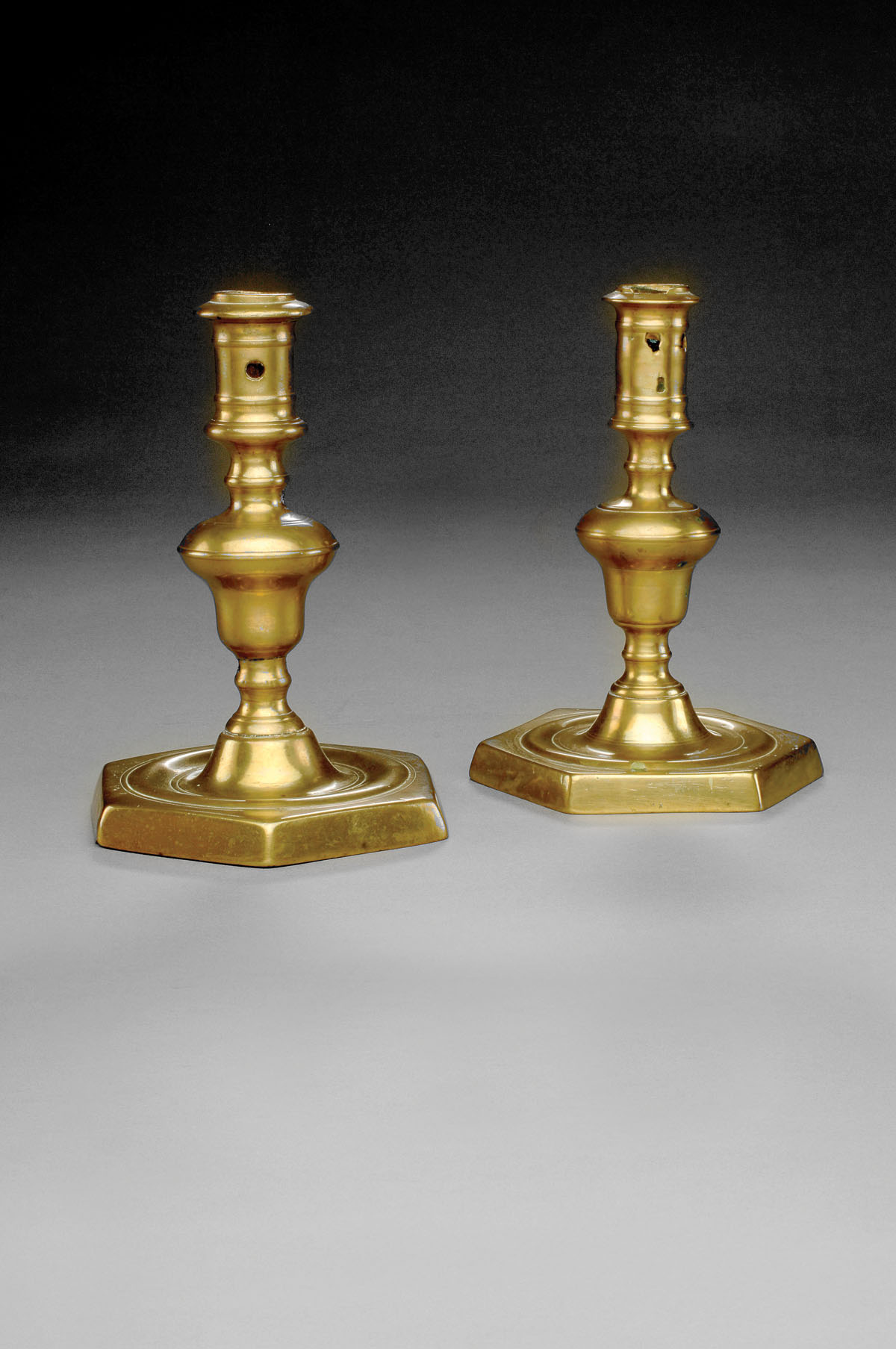 Appraisal: PAIR OF ENGLISH BRASS CANDLESTICKS Each cylindrical nozzle above an