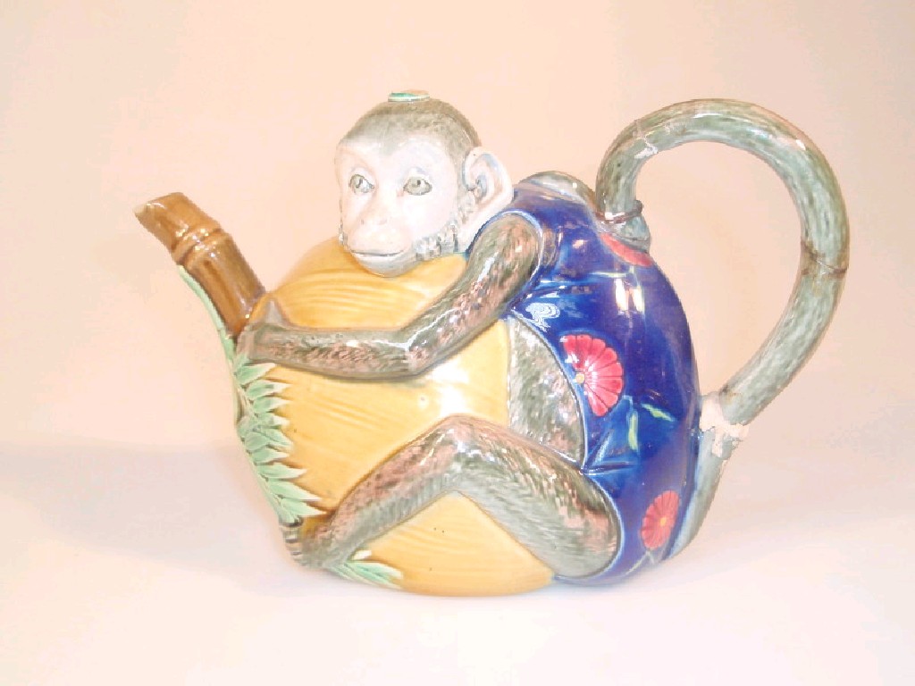 Appraisal: A Mintons Majolica Teapot modelled as a monkey clutching a