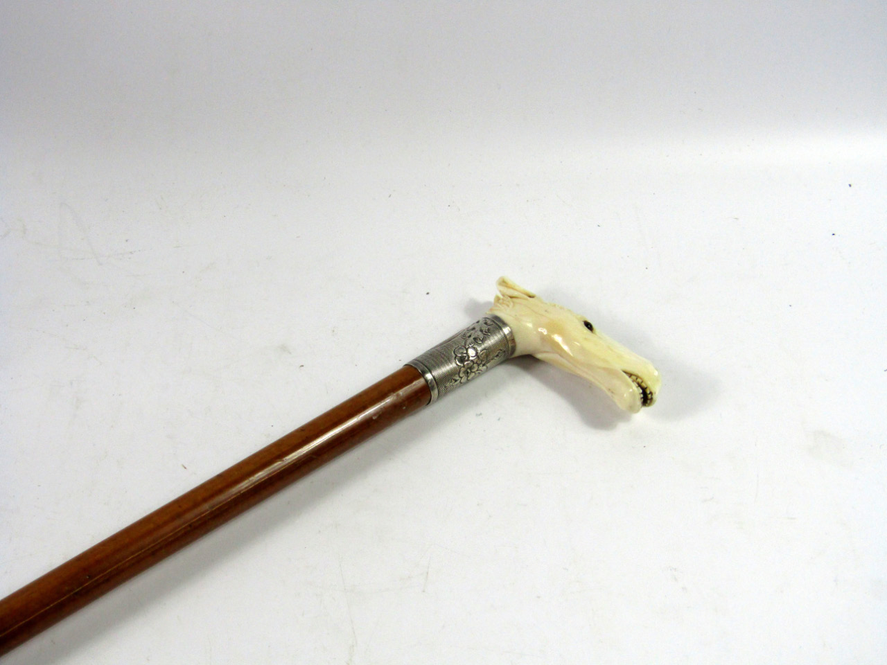 Appraisal: An Edwardian malacca walking stick with an ivory handle carved