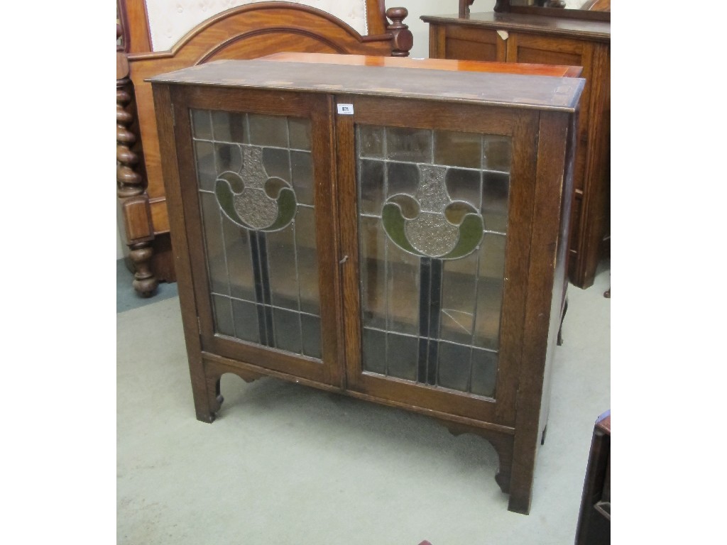 Appraisal: An Art Nouveau oak two door bookcase The doors decorated