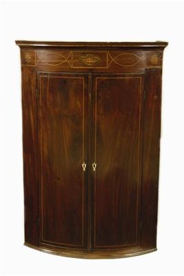 Appraisal: An early th century continental mahogany bowfront hanging corner cupboard