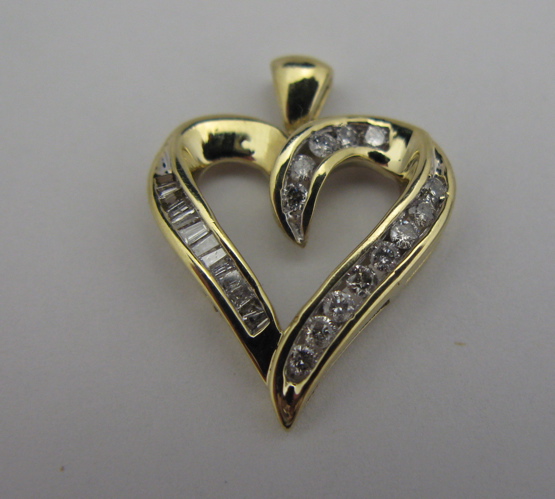 Appraisal: DIAMOND AND KARAT GOLD HEART PENDANT with round-cut and baguette