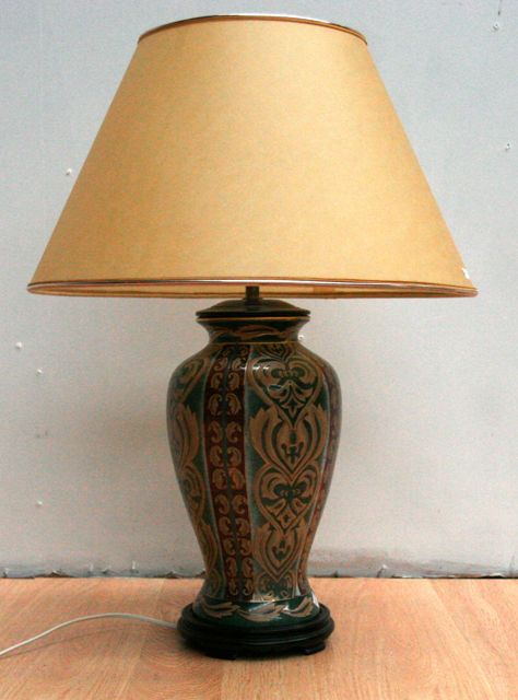 Appraisal: A ceramic lamp base on a wooden plinth with shade