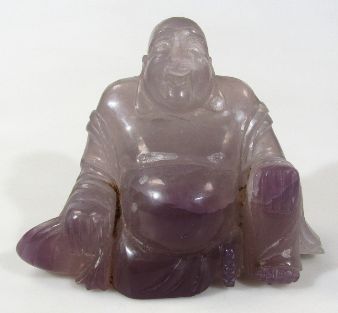 Appraisal: A thC Chinese amethyst coloured glass sculpture of Buddha in