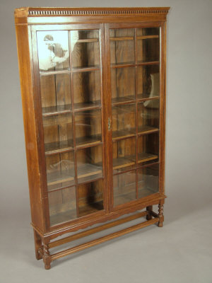 Appraisal: An oak glazed display cabinet on stand mid th century