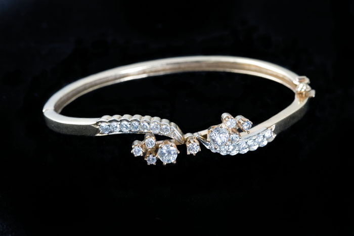 Appraisal: DIAMOND AND GOLD BANGLE BRACELET The bangle set with twenty-three