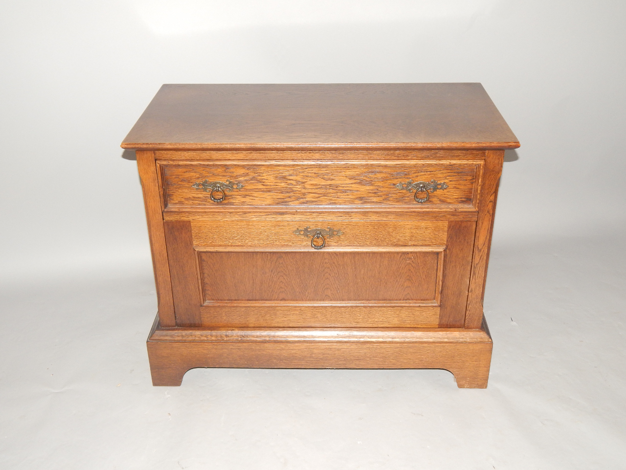 Appraisal: An oak side cabinet fitted with a shallow drawer and