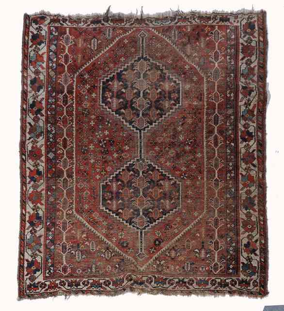 Appraisal: A SHIRAZ RUST GROUND RUG decorated a central stylised medallion