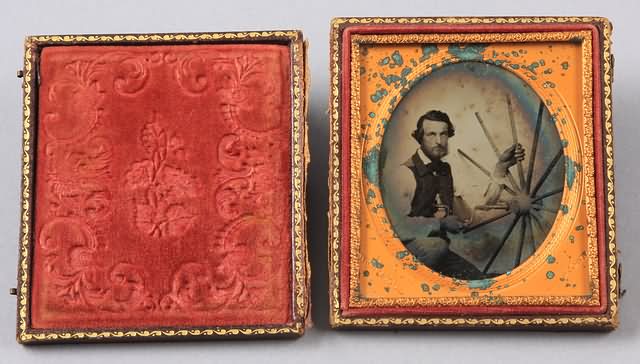 Appraisal: Sixth plate ruby ambrotype of seated man knees up holding