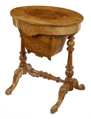 Appraisal: A walnut and inlaid oval sewing table the hinged top