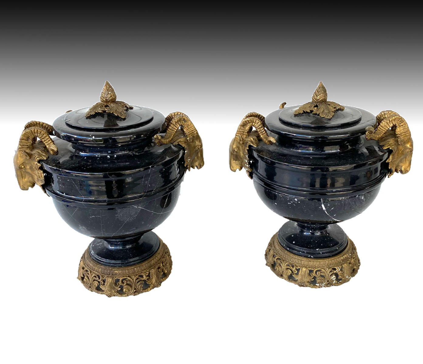 Appraisal: PAIR OF RAMS HEAD MARBLE COVERED URNS Large black marble