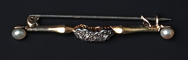 Appraisal: A diamond and half pearl bar brooch centred with a