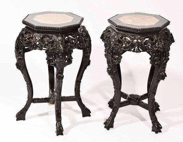 Appraisal: A CHINESE PAIR OF HARDWOOD OCTAGONAL URN STANDS each carved