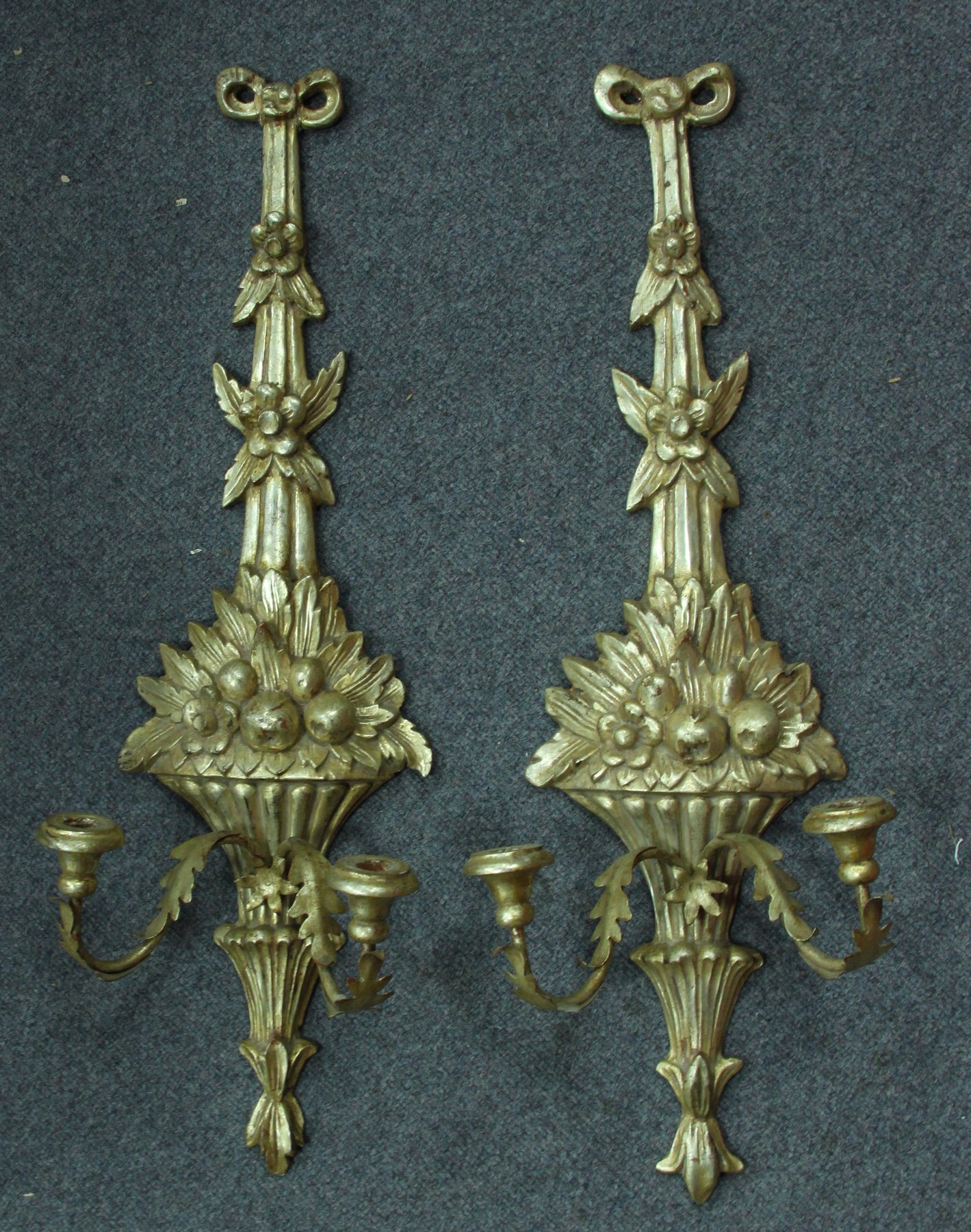 Appraisal: A carved and gilded pair of wall appliques each modelled