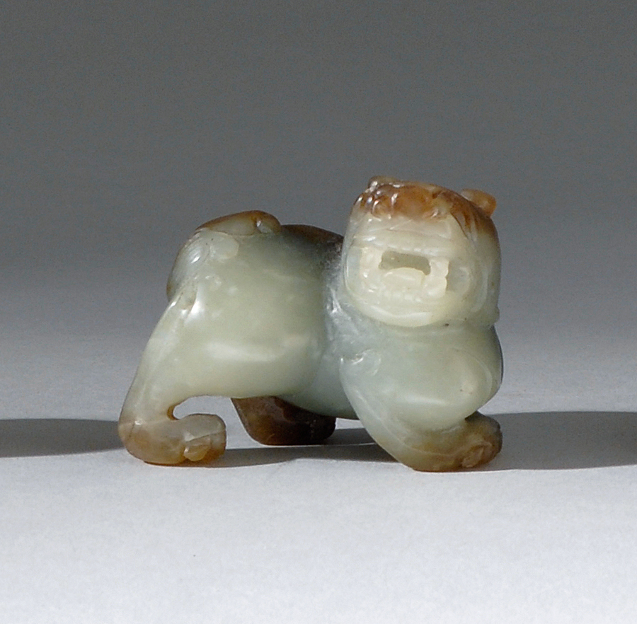 Appraisal: CELADON AND BROWN JADE CARVING In the form of a