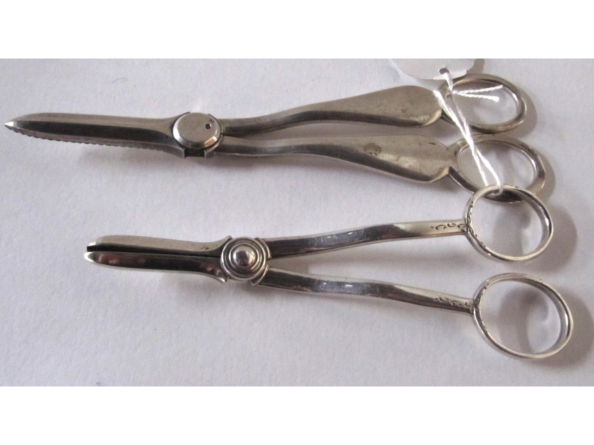 Appraisal: A lot comprising two pairs of silver grape scissors Sheffield