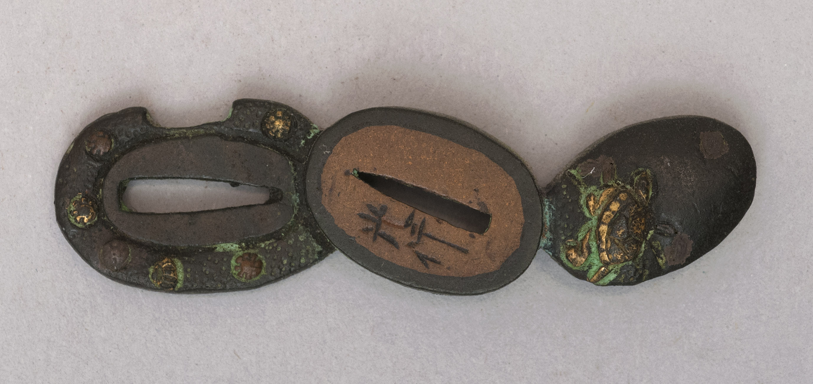 Appraisal: MIXED-METAL MENUKI th CenturyIn the form of a tsuba and