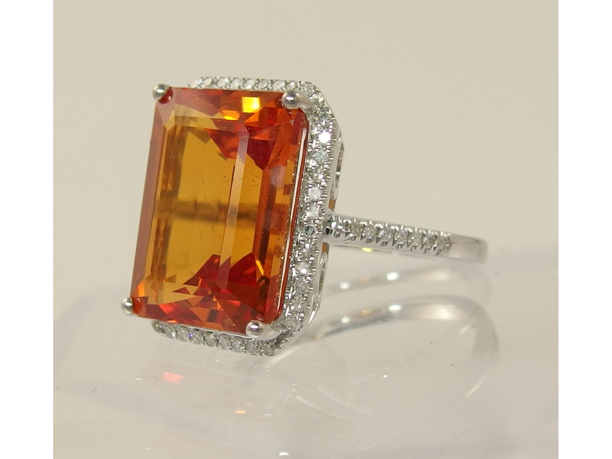 Appraisal: A ct ring set with an orange sapphire and diamonds