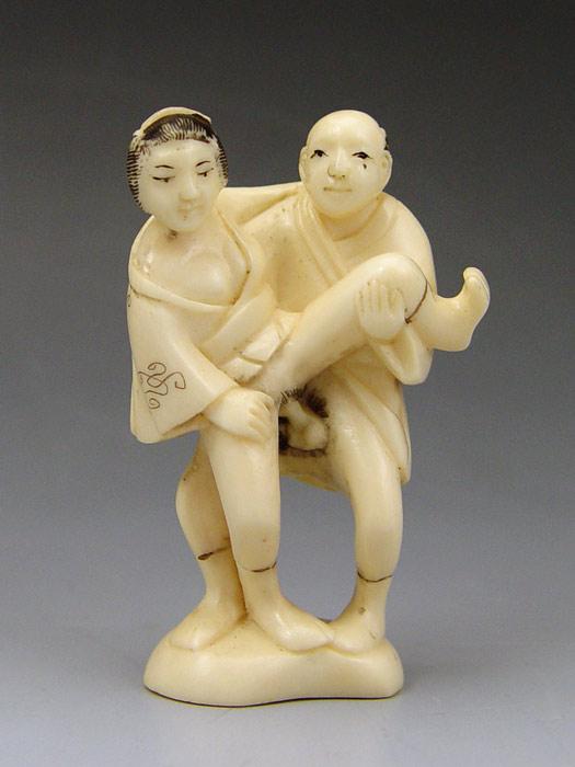 Appraisal: CARVED EROTIC IVORY STANDING COUPLE NETSUKE Couple in graphic standing