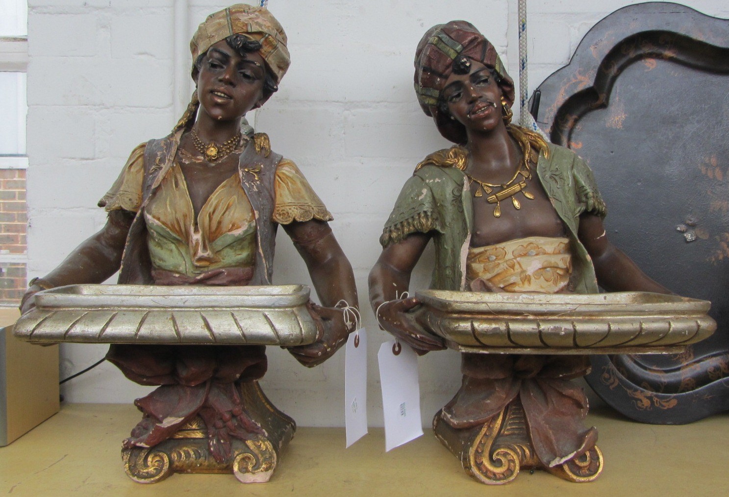 Appraisal: Two painted plaster busts of blackamores holding trays each cm