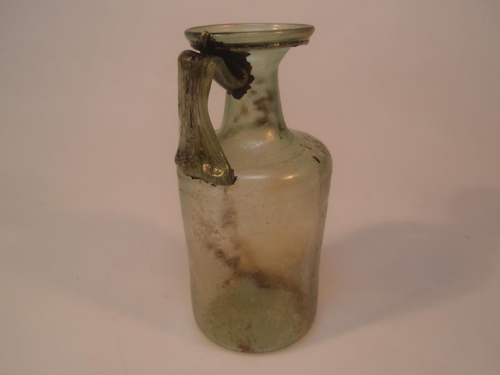 Appraisal: A tall light olive-green Roman cylindrical glass jug the flaring