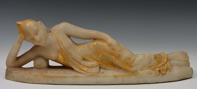 Appraisal: AN INDIAN ALABASTER FEMALE DEITY recumbent on an oval base