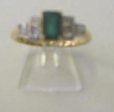 Appraisal: AN EMERALD AND DIAMOND RING the trapp cut emerald claw