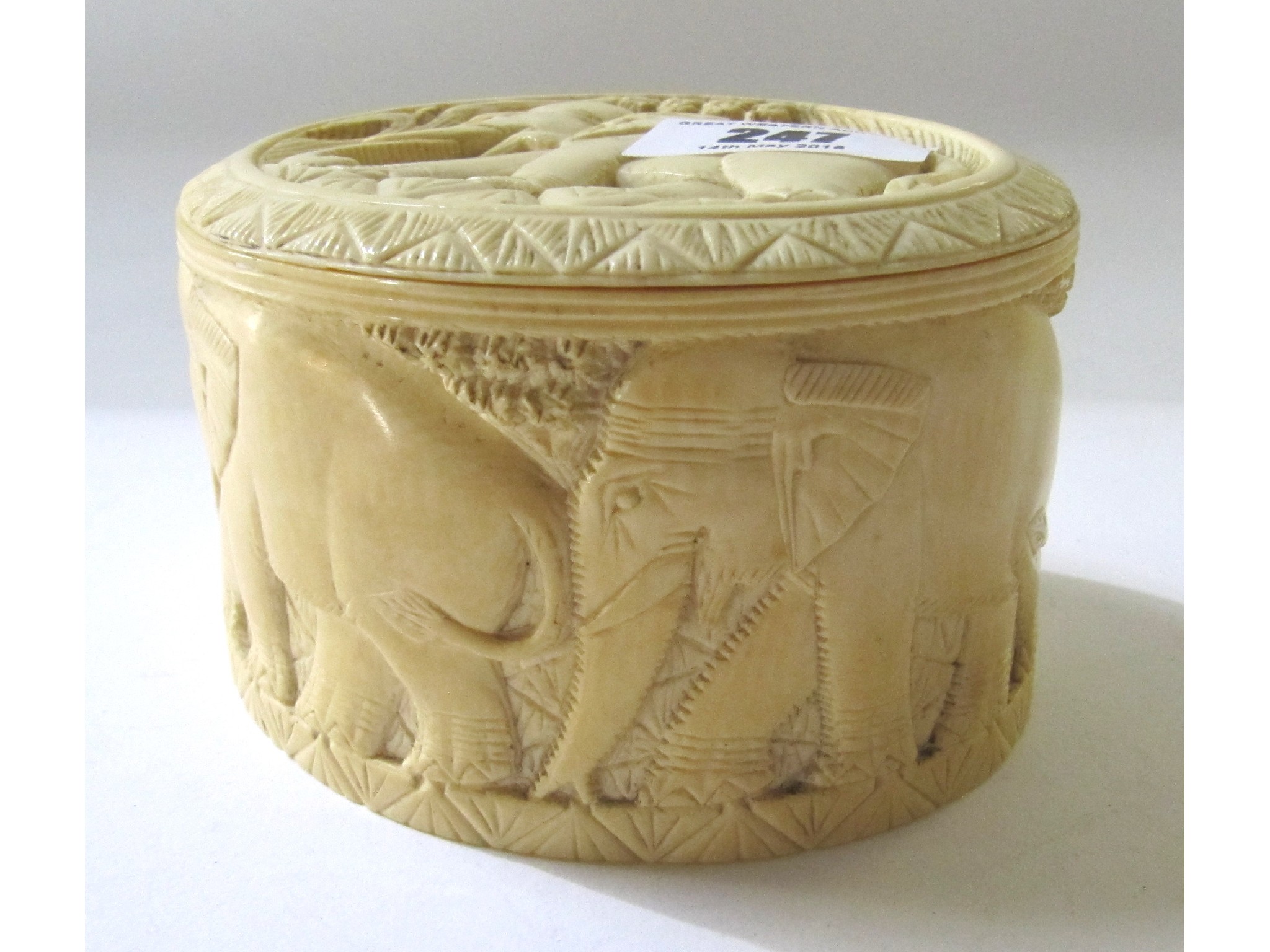 Appraisal: A carved ivory box and cover with elephant decoration