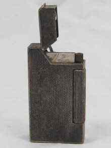 Appraisal: A silver plated Dunhill pocket petrol lighter with engine turned