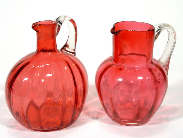 Appraisal: Two Cranberry glass jugs with clear handles the bodies of