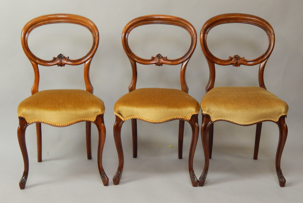 Appraisal: A set of three Victorian rosewood balloonback dining chairs with