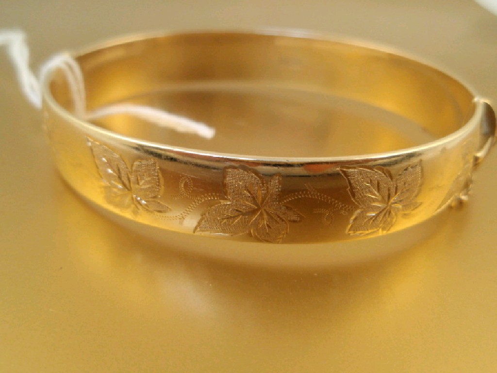 Appraisal: A ct gold hinged bangle with leaf decoration Birmingham assay