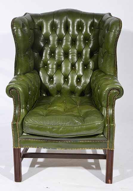 Appraisal: A GEORGIAN STYLE GREEN LEATHER BUTTON UPHOLSTERED WING BACK ARMCHAIR