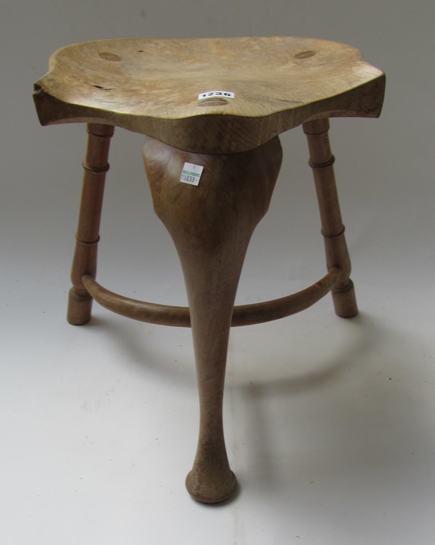 Appraisal: An ash and elm three legged stool with saddle seat